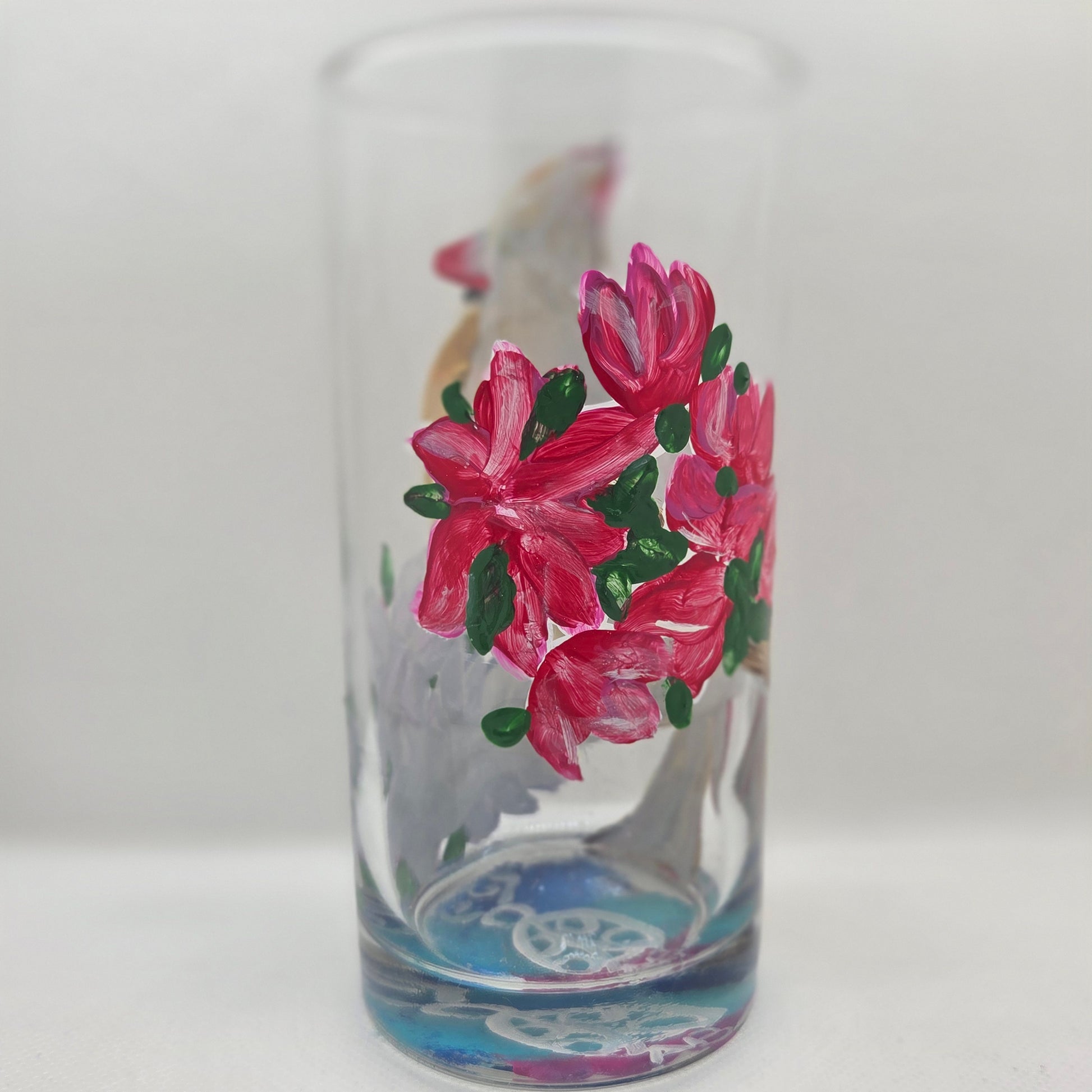 Hand-painted 16 oz tall tumbler with a female cardinal perched on a flowering branch surrounded by red, white, blue, and pink blossoms