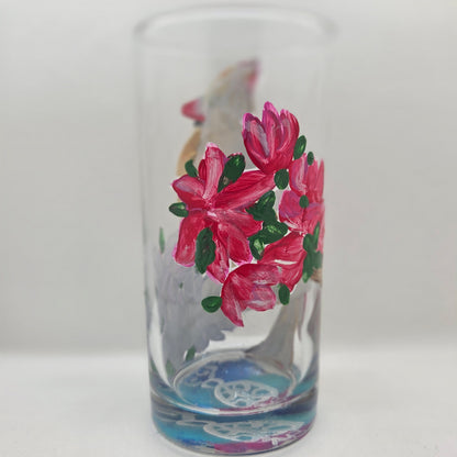 Hand-painted 16 oz tall tumbler with a female cardinal perched on a flowering branch surrounded by red, white, blue, and pink blossoms