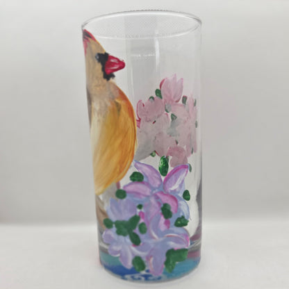 Hand-painted 16 oz tall tumbler with a female cardinal perched on a flowering branch surrounded by red, white, blue, and pink blossoms