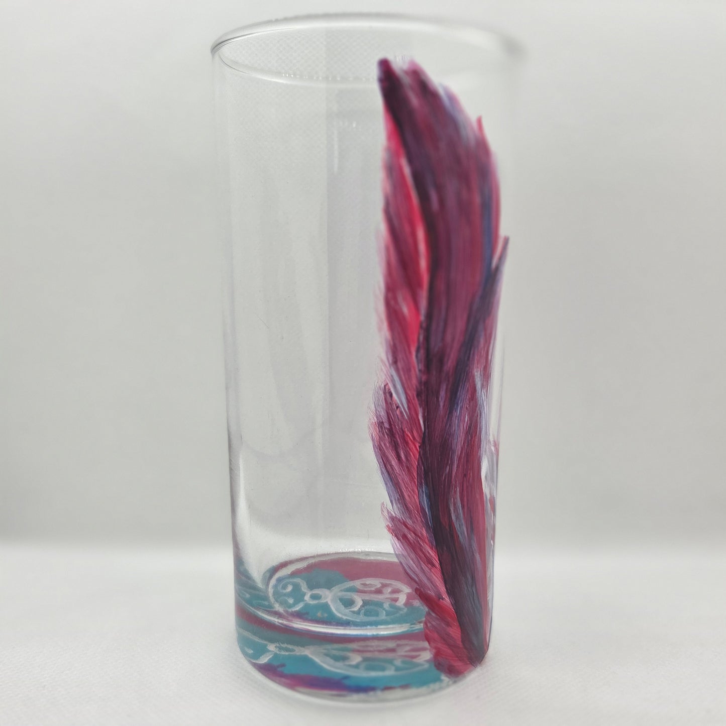 Hand-painted 16 oz tall tumbler with two flowing cardinal feathers in deep red, purple, cobalt blue, and white