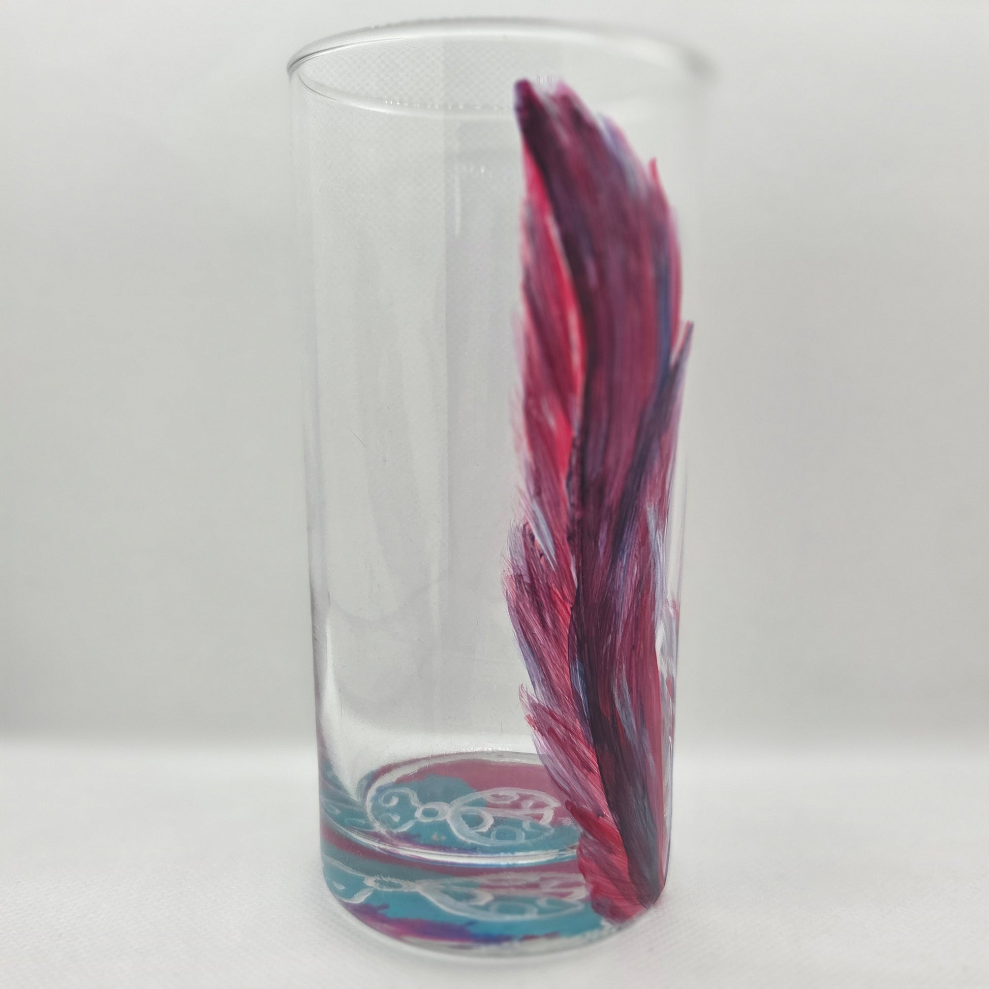 Hand-painted 16 oz tall tumbler with two flowing cardinal feathers in deep red, purple, cobalt blue, and white