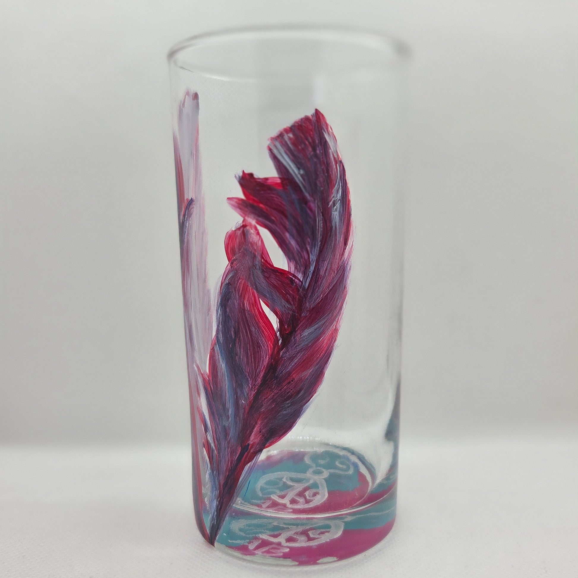 Hand-painted 16 oz tall tumbler with two flowing cardinal feathers in deep red, purple, cobalt blue, and white