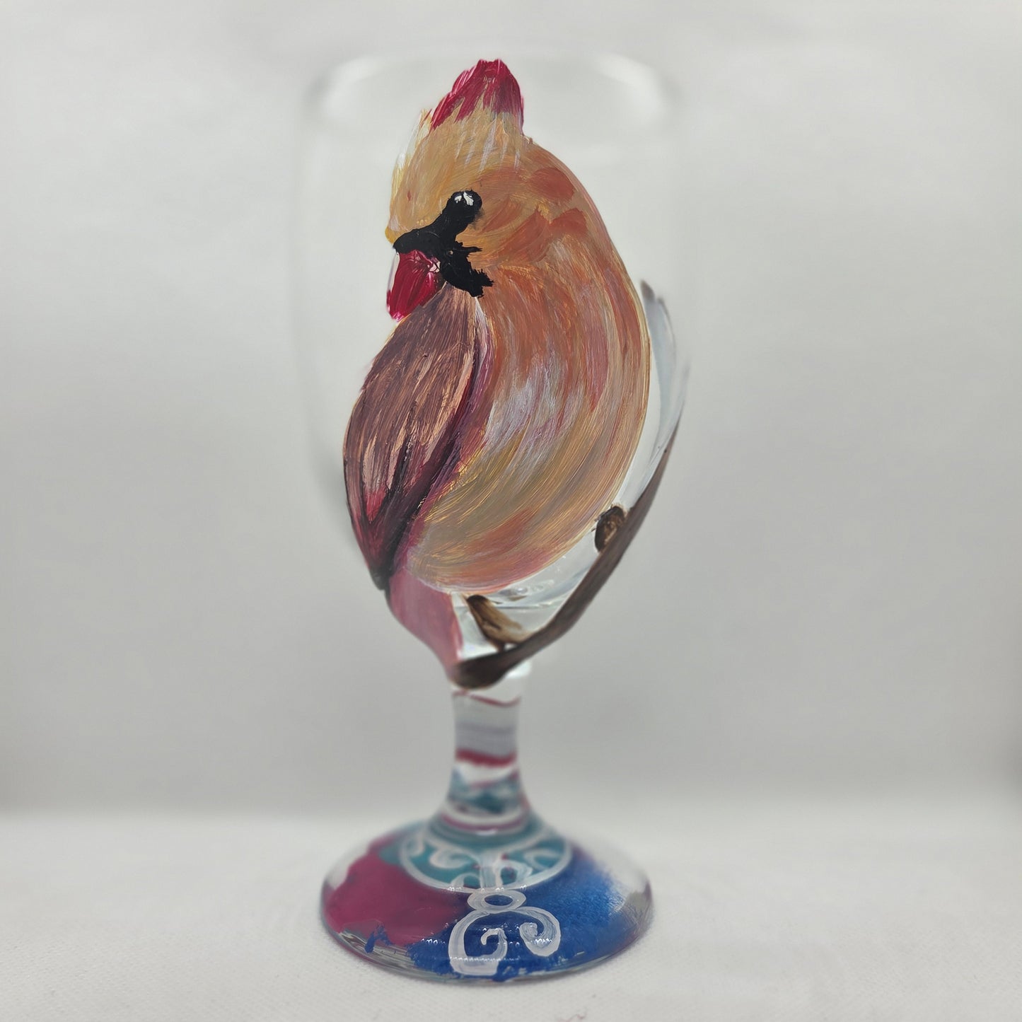 Hand-painted 16 oz goblet with a female cardinal looking over her shoulder, perched on a branch with peach-pink coloring