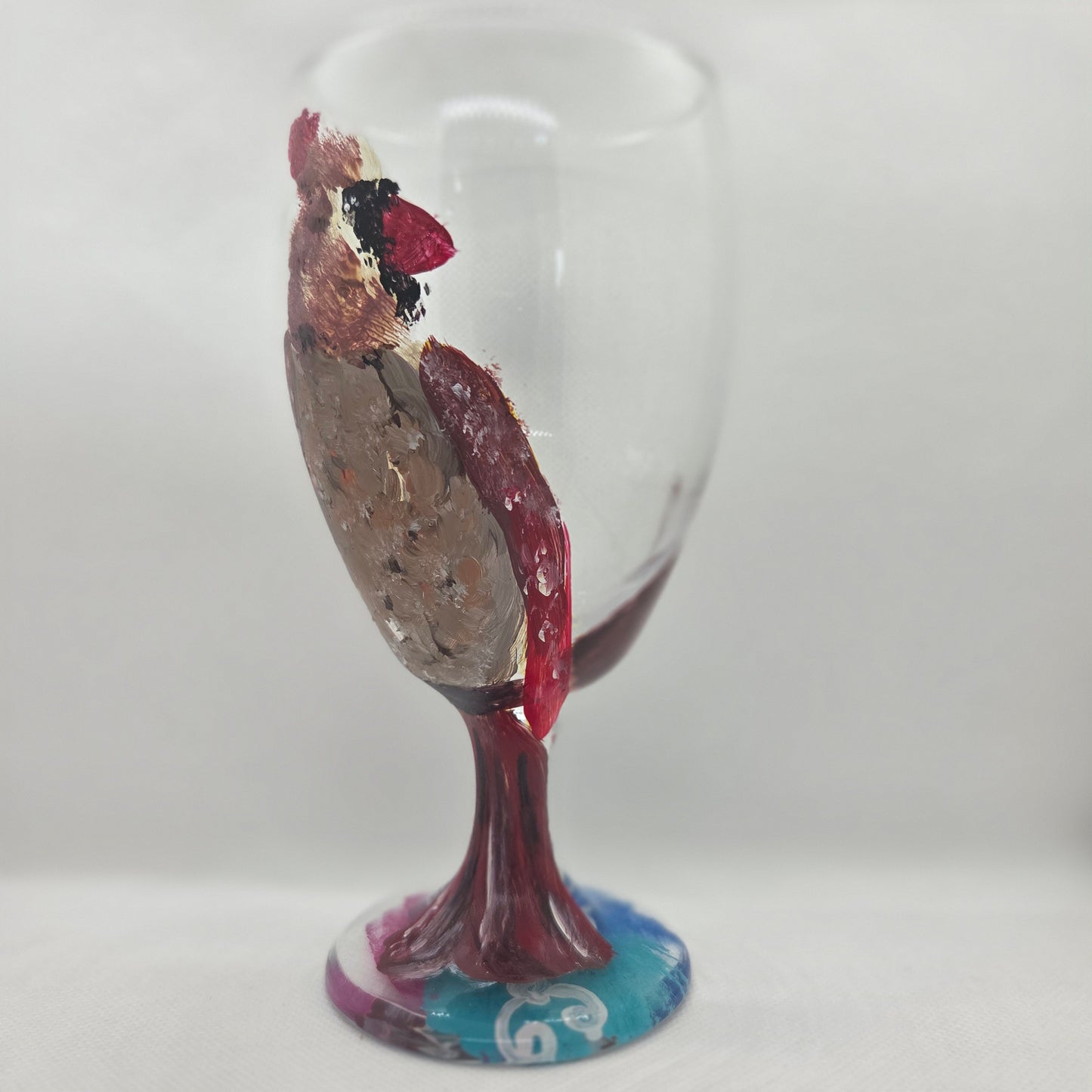 Hand-painted 16 oz goblet with a fluffy female cardinal perched on the bowl and tail feathers extending down the stem