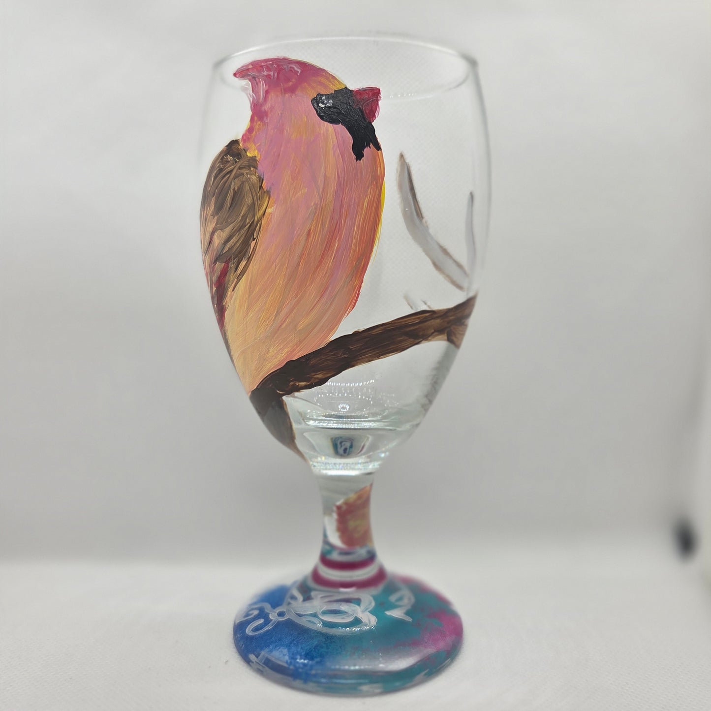 Hand-painted 16 oz glass with a pink-toned female cardinal perched on a branch and looking upward