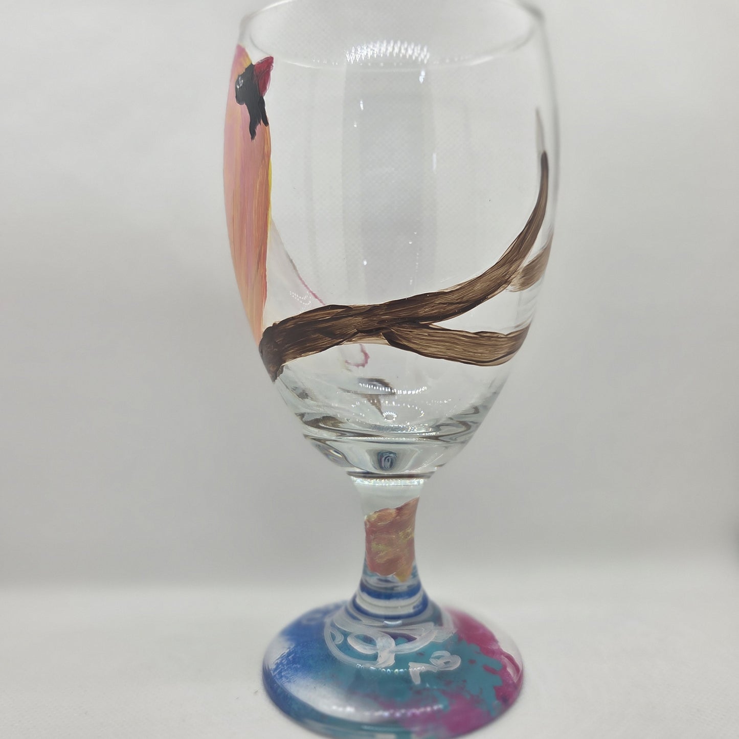Hand-painted 16 oz glass with a pink-toned female cardinal perched on a branch and looking upward
