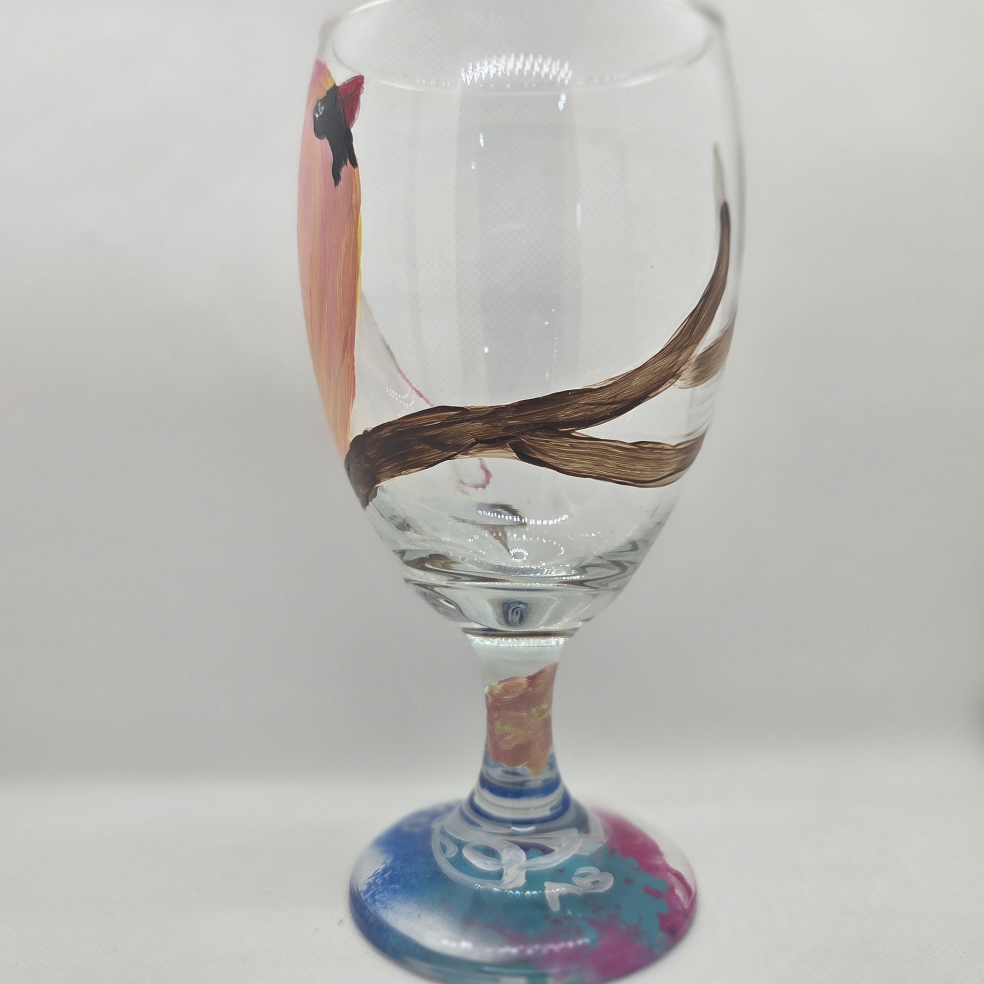 Hand-painted 16 oz glass with a pink-toned female cardinal perched on a branch and looking upward
