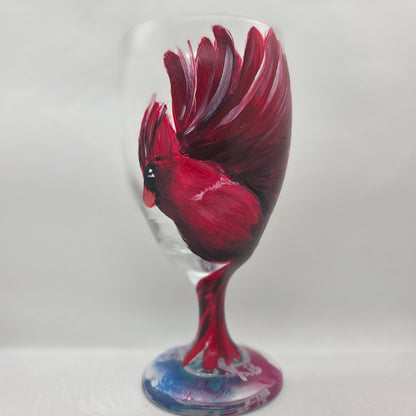 Hand-painted glass featuring a red male cardinal in flight looking down as he approaches his landing perch