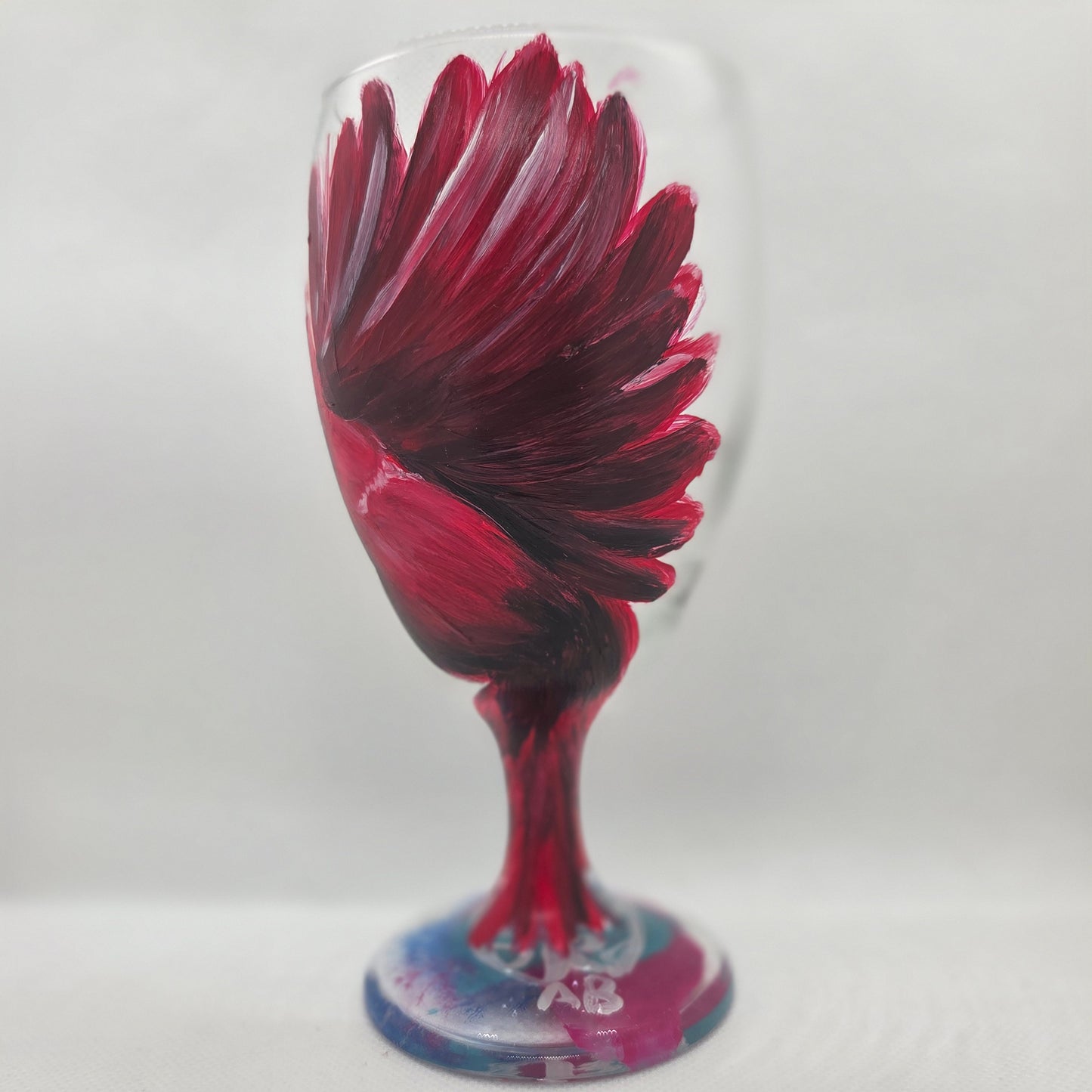Hand-painted glass featuring a red male cardinal in flight looking down as he approaches his landing perch