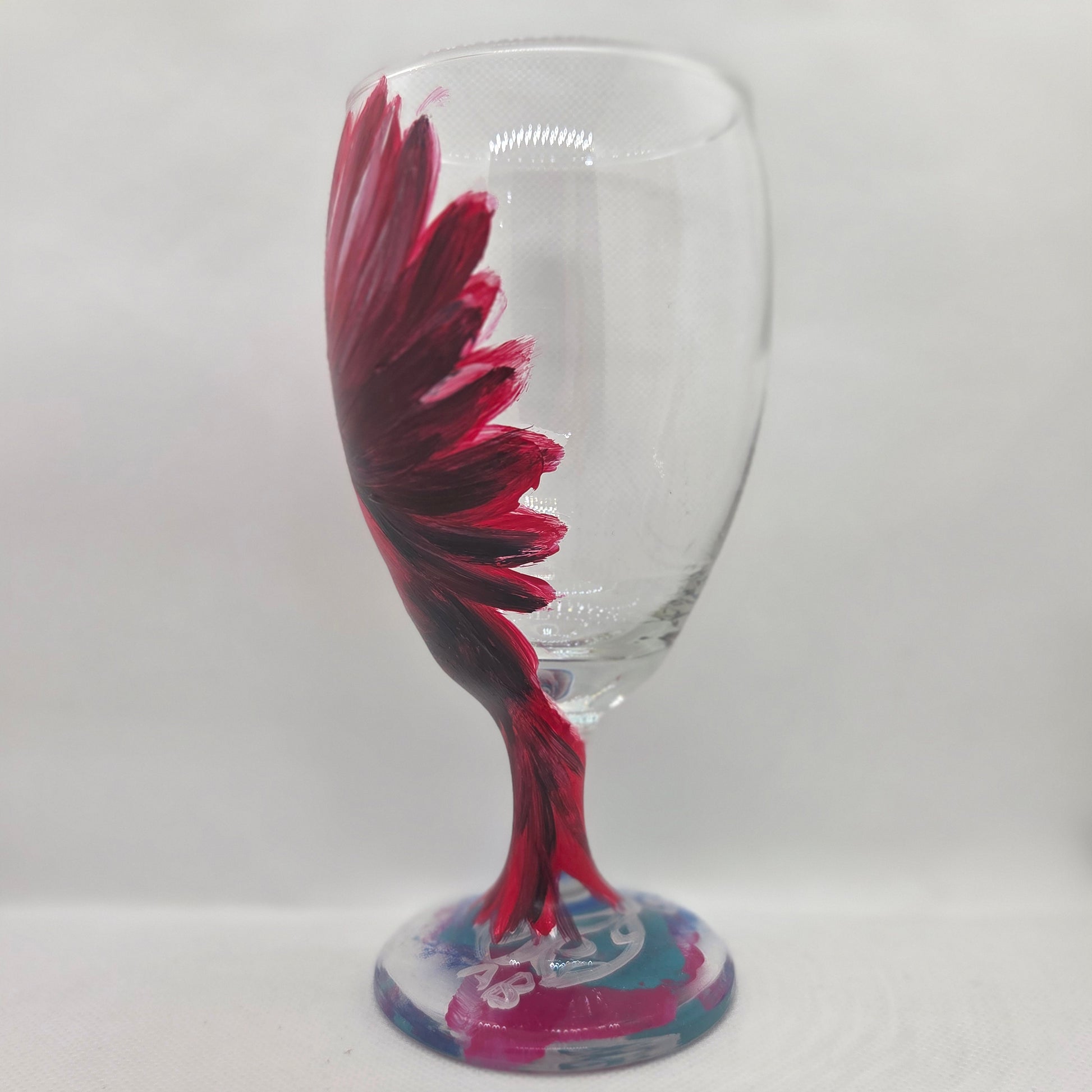 Hand-painted glass featuring a red male cardinal in flight looking down as he approaches his landing perch