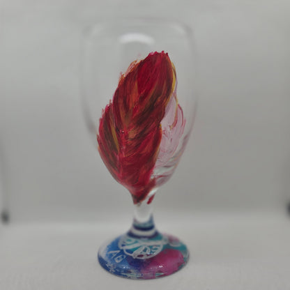 Hand-painted 16 oz goblet with two upright cardinal feathers in red, orange, and golden yellow