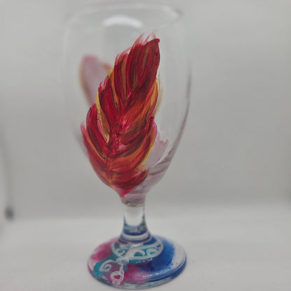 Hand-painted 16 oz goblet with two upright cardinal feathers in red, orange, and golden yellow