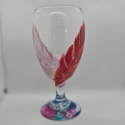 Hand-painted 16 oz goblet with two upright cardinal feathers in red, orange, and golden yellow