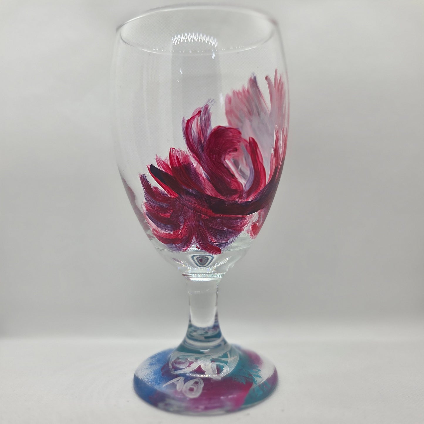 Hand-painted 16 oz goblet with a floating cardinal feather in bold red with black and subtle purple shadows