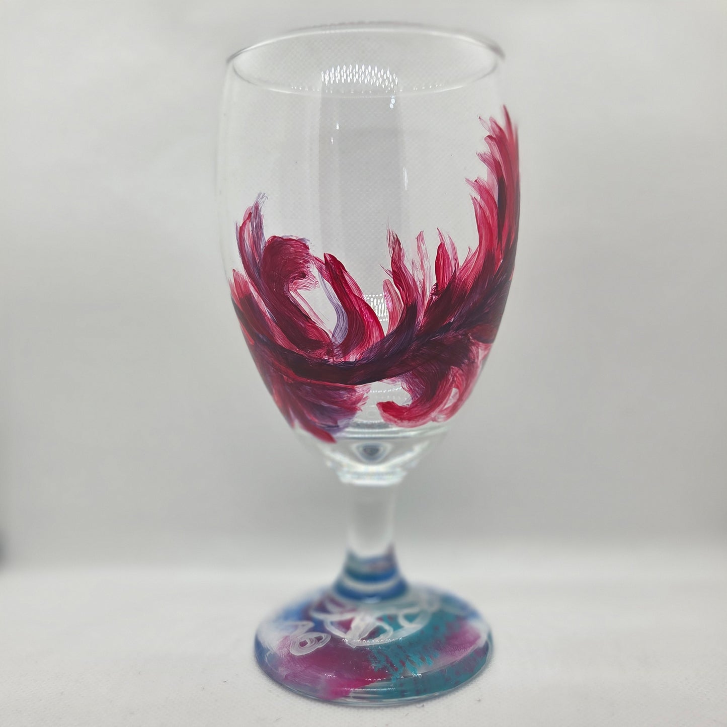 Hand-painted 16 oz goblet with a floating cardinal feather in bold red with black and subtle purple shadows
