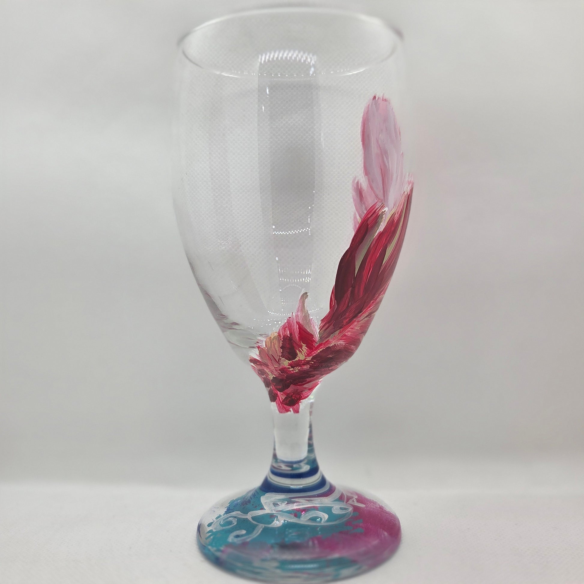 Hand-painted 16 oz glass with a graceful cardinal feather in brilliant red, orange, and golden yellow